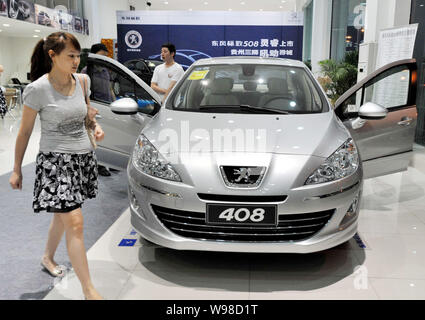 --FILE--cinese gli acquirenti di auto guarda la Peugeot 408 presso un concessionario Peugeot nella città di Guiyang, southwest Chinas Guizhou, 11 luglio 2011. Auto sal Foto Stock