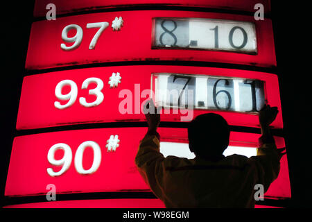 Un lavoratore aggiorna i prezzi del carburante in corrispondenza di una stazione di rifornimento a Pechino, in Cina, il 9 ottobre 2011. Benzina e diesel i prezzi sono ridotti per la prima volta quest'anno Foto Stock