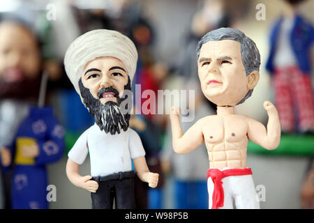 Figurine di Osama bin Laden e George W Bush sono in vendita in un negozio presso il mercato dei prodotti del Giardino di Yu in Cina a Shanghai, 3 maggio 2011. Negozio di souvenir Foto Stock