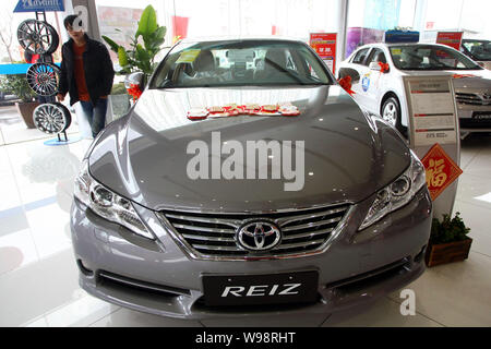 Un uomo cinese guarda una Toyota Reiz presso un concessionario in Cina a Shanghai, 28 gennaio 2011. Laccati. car makers, già scossa dalla countrys natu Foto Stock