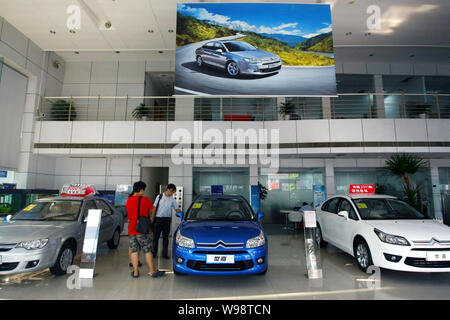 --FILE--cinese gli acquirenti di auto guarda le automobili Citroen presso un concessionario Citroen in Cina a Shanghai, 8 settembre 2010. Dongfeng Peugeot Citroen Automobile Co Foto Stock