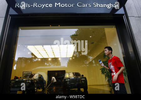 --File -- un giovane uomo cinese sorge fuori la Rolls-Royce showroom di Xintiandi in Cina a Shanghai, 27 luglio 2010. Non appena la Rolls Royce boss Torst Foto Stock
