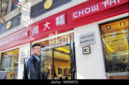 --FILE--un residente locale passeggiate passato un negozio gioielli di Chow Tai Fook in Cina a Shanghai, 11 marzo 2011. Hong Kong Jewellery rivenditore Chow Tai Fook, co Foto Stock