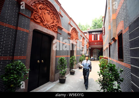 --FILE--un cinese la guardia di sicurezza passeggiate in corsia presso il sito del primo Congresso nazionale del Partito Comunista della Cina nei pressi di Xintiandi, un ufficio del turism Foto Stock