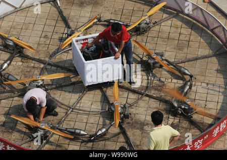 L'agricoltore cinese shu Mansheng, centro e il suo partner controllare il Flying Saucer prima di un test nel villaggio di Dashu, Wuhan City Central Chinas Hubei provinc Foto Stock