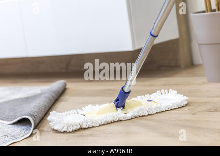 Moderno e di colore bianco mop utilizzato per la pulizia di un pavimento in legno Foto Stock