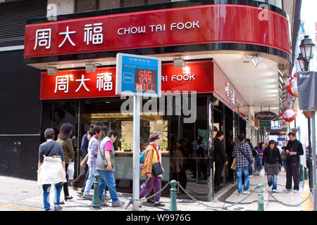 --FILE--pedoni a piedi passato un Chow Tai Fook gioielleria in Macau, Cina, 7 dicembre 2011. Chow Tai Fook Jewellery Group Ltd. cadde sul suo primo tr Foto Stock