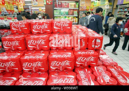 --FILE--acquirenti cinesi a piedi passato un contatore di promozione della Coca Cola in un supermercato in città Haian, est Chinas provincia dello Jiangsu, 16 febbraio 2011. C Foto Stock