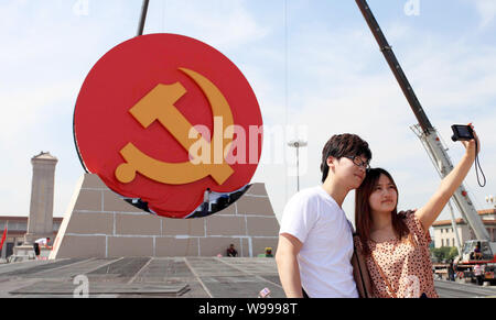 I turisti scattare foto di fronte a un enorme emblema del Partito Comunista della Cina (CPC) essendo installati su Piazza Tiananmen a Pechino in Cina, 27 Giugno 20 Foto Stock