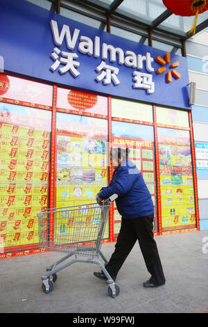 --FILE--un acquirente cinese spinge un carrello della spesa in un supermercato Walmart in Cina a Shanghai, 27 gennaio 2011. Wal-Mart Stores Inc., i mondi bigg Foto Stock