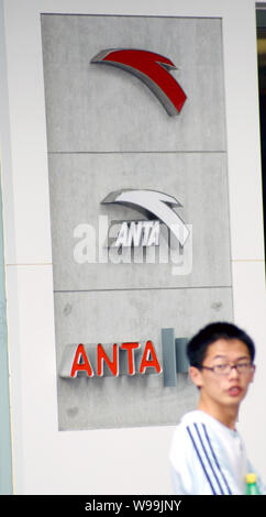 --File-- un giovane uomo cinese passeggiate passato il logo di anta a Suzhou City East Chinas provincia dello Jiangsu, 28 giugno 2009. Anta Sports prodotti effettuate al netto Foto Stock