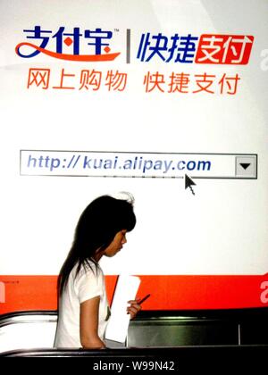 --File--A passeggiate a piedi passato un annuncio per Alipay in Cina a Shanghai, 21 agosto 2011. Alipay.com, il Internet di terze parti subsidi pagamento Foto Stock