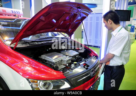 Un uomo cinese guarda una BYD e6 auto elettrica durante il 2010 la Cina (Shenzhen) Fiera Internazionale per la conversione dei risultati della ricerca nel settore dell'energia-savi Foto Stock