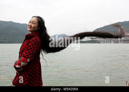 Migrante cinese Cheng Shiqun mostra i suoi capelli lunghi per contrassegnare il livello di acqua del fiume Yangtze raggiungendo i 174 metri in tre gole serbatoio a Yun Foto Stock