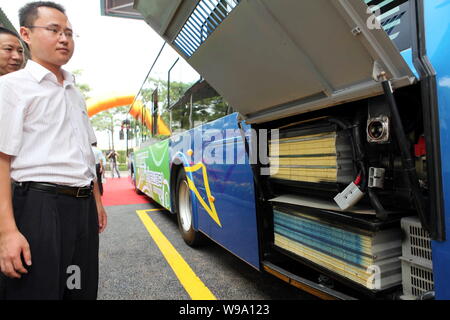 Visitatori cinesi guardare le batterie di un bus elettrico durante la cerimonia di lancio di una stazione di carica di membro Grid Corporation della Cina in Xiame Foto Stock