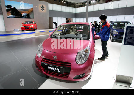 Un lavoratore cinese pulisce un Changan Suzuki auto durante un auto show di Pechino, Cina, 25 aprile 2010. Chongqing Changan Suzuki Automobile Co Ltd, a mi Foto Stock