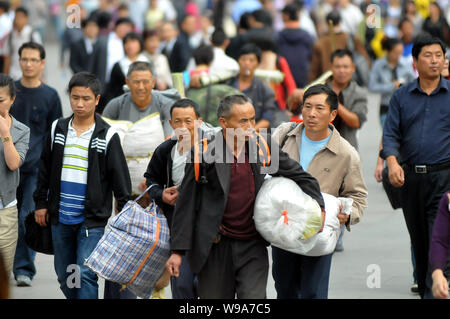 --FILE--cinese lavoratori migranti a piedi sulla piazza della Stazione Ferroviaria di Shanghai in Cina a Shanghai, 7 ottobre 2010. Shanghais po migranti Foto Stock