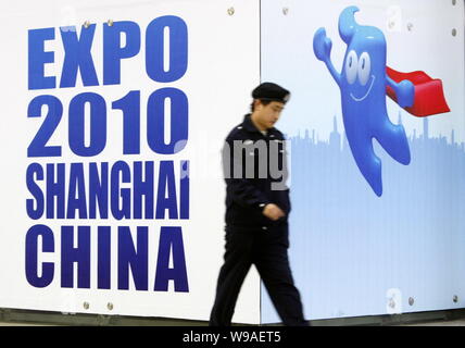 Un cinese la guardia di sicurezza passeggiate passato manifesti pubblicitari per il World Expo 2010 a una stazione della metropolitana di Shanghai, Cina, 19 aprile 2010. Shanghai è p Foto Stock