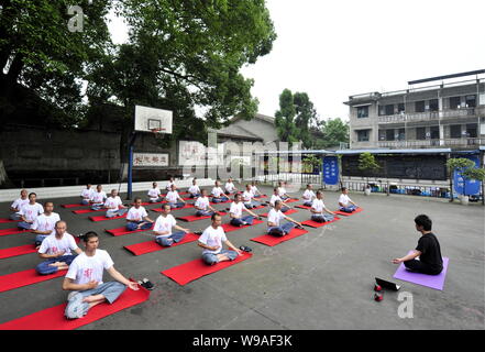 27 detenuti cinesi e un insegnante di yoga eseguire lo yoga in una prigione della città di Chengdu, southwest Chinas nella provincia di Sichuan, 18 giugno 2010. Il 27 prigionieri wi Foto Stock