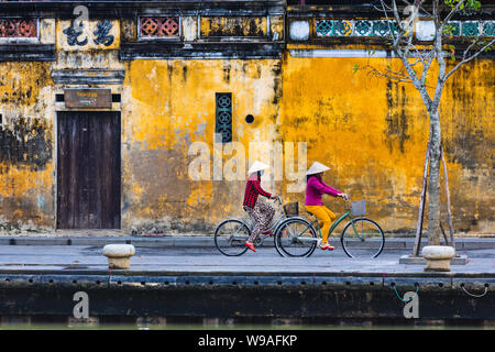HOI AN, VIETNAM - Gennaio 1, 2018: Donna guidare la bicicletta in Hoi An, Vietnam Foto Stock
