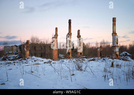 Rovine di un olocausto di legno fuori casa a 2 piani su un Gennaio sera. Abbandonato il villaggio di lavoro nella regione di Leningrado (America russa). La Russia Foto Stock