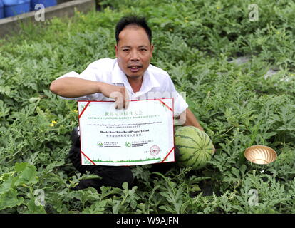 L'agricoltore cinese Peng Qiugen mostra il diploma per il tetto del mondo riso persone migliori Award nel campo di cocomero sul tetto dei suoi 3 piani in casa Foto Stock