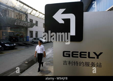 Un uomo cinese passeggiate passato un segno che mostra la direzione di una Geely store in Cina a Shanghai, Agosto 4, 2010. Geely Automobile Holdings Ltd. non p Foto Stock