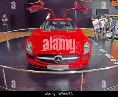 Giovani uomini cinesi guardare una Mercedes SLS AMG durante un auto show di Chongqing Cina, 12 giugno 2010. Casa automobilistica tedesca Daimler AGs Mercedes-Benz Foto Stock