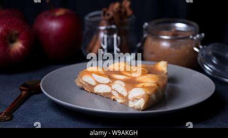 Torta di gelificata di salsa di mele e biscotti ladyfinger. Una forma triangolare slice. Foto Stock