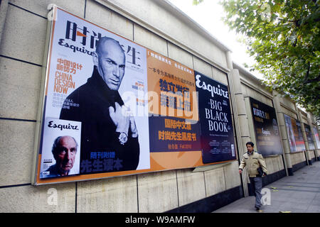 Un uomo cinese passeggiate passato un poster pubblicitario per la Cinese-versione 2010 numero di novembre di Esquire con l immagine del francese ex superstar soccer Foto Stock