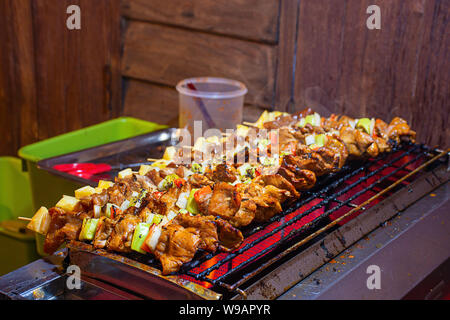 Barbecue grigliate di carne con verdure e salsa di pomodoro sulle griglie di acciaio con il calore. Foto Stock