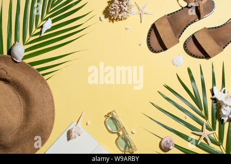 Sandali di cuoio e tropicale di foglie di palma, conchiglie, stelle marine su sfondo bianco. Estate sfondo. Foto Stock