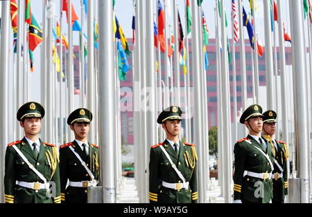 Soldati cinesi stare accanto a bandiere nazionali dei paesi che partecipano al Shanghai World Expo durante l alzabandiera cerimonia in Expo Foto Stock