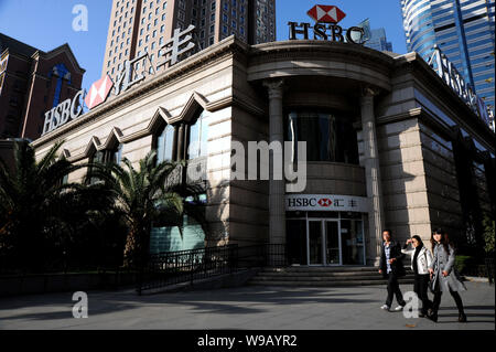 I residenti locali a piedi passato un ramo di HSBC in Cina a Shanghai, 4 dicembre 2010. Dopo due decenni trascorsi in espansione in Gran Bretagna, gli Stati Uniti e Foto Stock