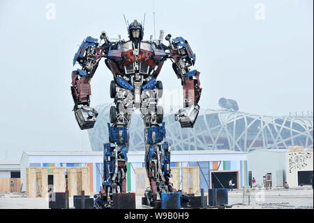 Una replica di Optimus Prime, il robot leader degli Autobot nel film trasformatore, viene visualizzato vicino al National Stadium, noto come il nido di uccelli, in Foto Stock