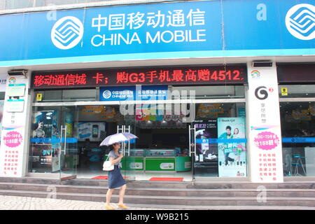 Una donna cinese passeggiate passato un ramo di China Mobile a Chongqing, Cina, 1 settembre 2010. Vodafone Group plc è il più grande di telefono mobile dalla società Foto Stock