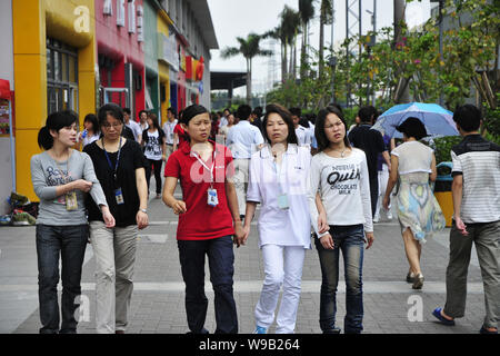 Cinese i dipendenti Foxconn a piedi passato negozi in Shenzhen stabilimento di Foxconn Technology Group nella città di Shenzhen, sud Chinas nella provincia di Guangdong, 8 Maggio 2 Foto Stock