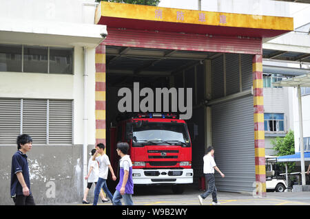 Cinese i dipendenti Foxconn a piedi passato una stazione dei vigili del fuoco in Shenzhen stabilimento di Foxconn Technology Group nella città di Shenzhen, sud Chinas provincia di Guangdong Foto Stock