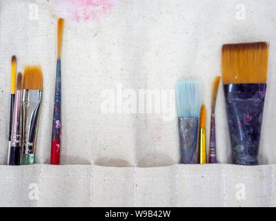 Artista pennelli. Lay piatto di molti strumenti di artista in vernice calico portaspazzole, apparecchiatura di arte. Foto Stock