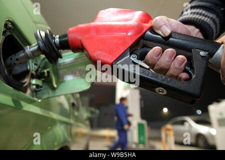 Un Cinese taxi driver refuels la sua auto in una stazione di gas prima che il carburante i prezzi sono aggiornati nella città di Nantong, est Chinas provincia dello Jiangsu, 21 Dicembre 2 Foto Stock