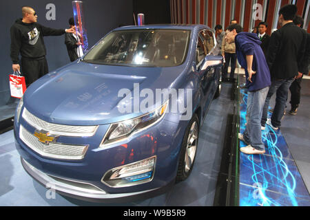 Visitatori guardare una Chevrolet auto durante un auto show di Pechino, Cina, 29 aprile 2010. La General Motors ha fatto un trionfante ritorno alla parete Stre Foto Stock