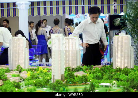 Un homebuyer cinese guarda al modello di edifici di un progetto residenziale durante una fiera immobiliare a Pechino in Cina, 24 giugno 2010. Nuovo home prezzi in Foto Stock