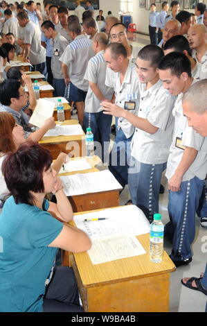 Maschio cinese detenuti che completeranno il loro periodo di reclusione folla alcune cabine di compaines durante una fiera del lavoro in un carcere di Nanchang, Oriente Cina Foto Stock