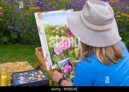 Artista Nina scudiero di catturare la bellezza dei fiori di prato di fiori a New Forest & Hampshire County Show, Brockenhurst, Hampshire REGNO UNITO NEL MESE DI LUGLIO Foto Stock