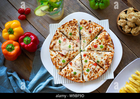 Pizza su una tavola di legno con ingredienti dalla vista superiore Foto Stock
