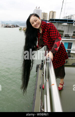 Migrante cinese Cheng Shiqun mostra i suoi capelli lunghi per contrassegnare il livello di acqua del fiume Yangtze raggiungendo i 174 metri in tre gole serbatoio a Yun Foto Stock