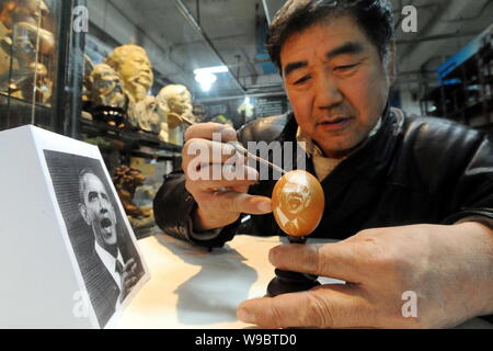 Folk Cinese scultore Kang Yongguo scolpisce il ritratto di U.S. Il presidente Barack Obama il guscio di un uovo di gallina nel suo studio di Shenyang city, n. Foto Stock