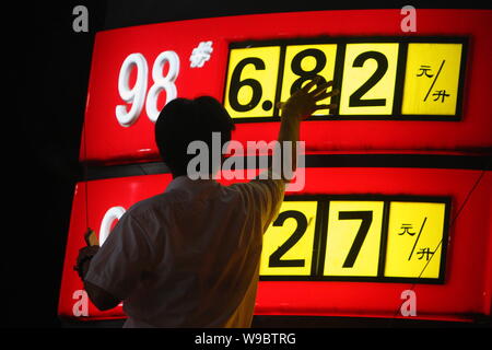 Un cinese alla stazione di servizio lavoratore aggiorna i prezzi del carburante in corrispondenza di una stazione di rifornimento di Sinopec a Pechino, Cina, lunedì, 1 giugno 2009. La Cina è aumentato il prezzo del carburante Foto Stock