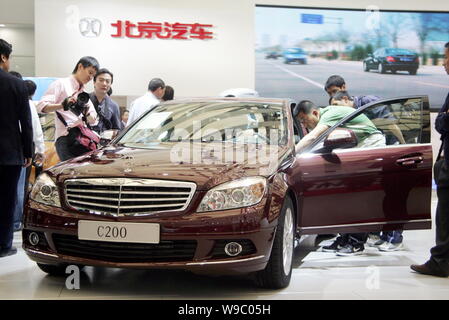 --FILE--i visitatori guardano una Mercedes-Benz C200 al tredicesimo Shanghai industria automobilistica internazionale mostra, noto come auto Shanghai 2009, Shang Foto Stock
