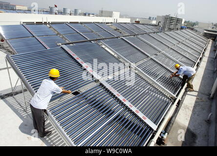 --FILE--lavoratori cinesi installare energia solare di acqua calda sulla parte superiore di un edificio di Chongqing Cina, 29 luglio 2009. Porcellane i legislatori hanno presentato Foto Stock
